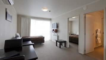 Una habitación de hotel con una cama, un escritorio, una silla, un televisor y una ventana.