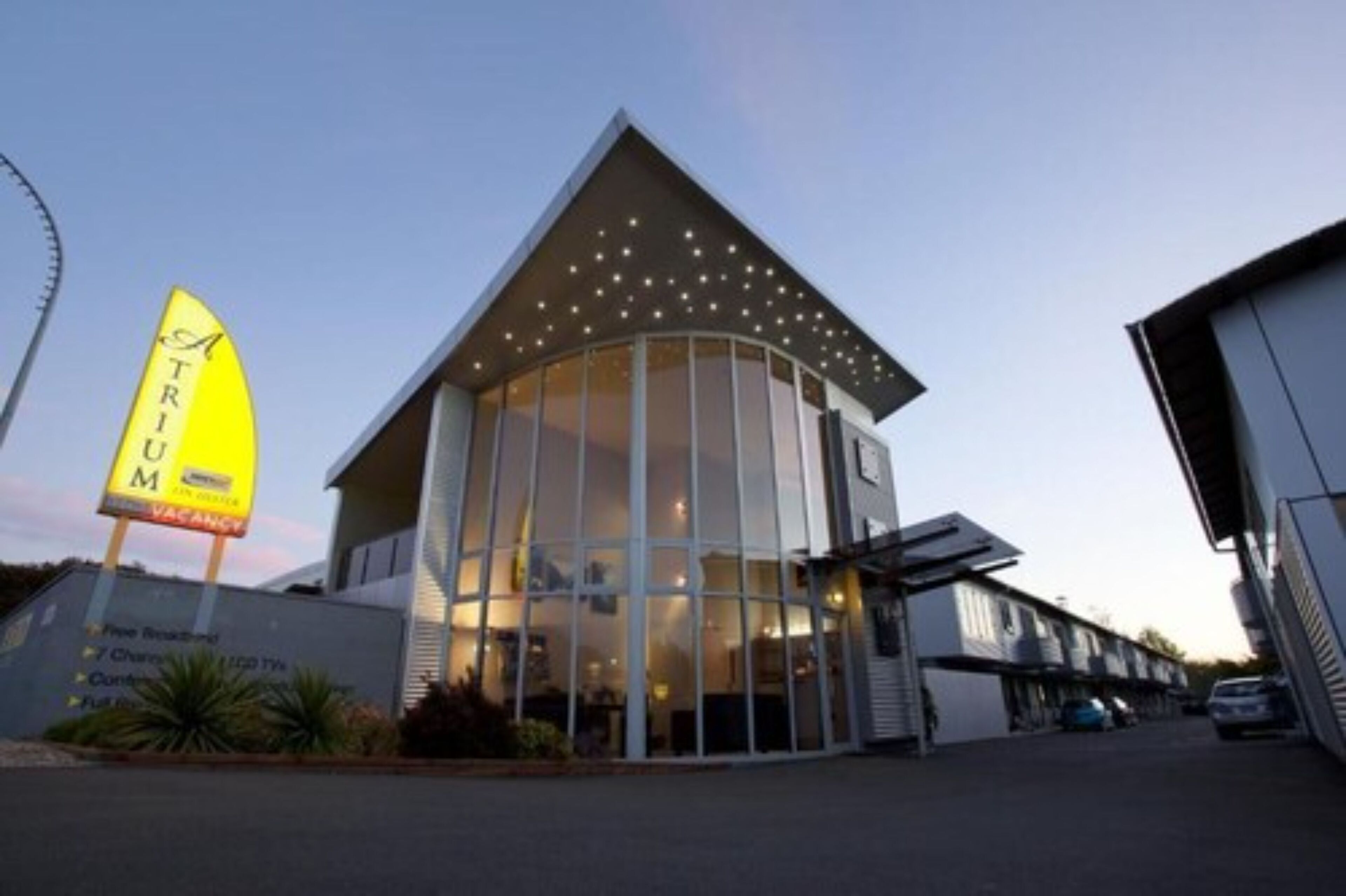 A modern building with a glass facade and a sign indicating a vacancy.