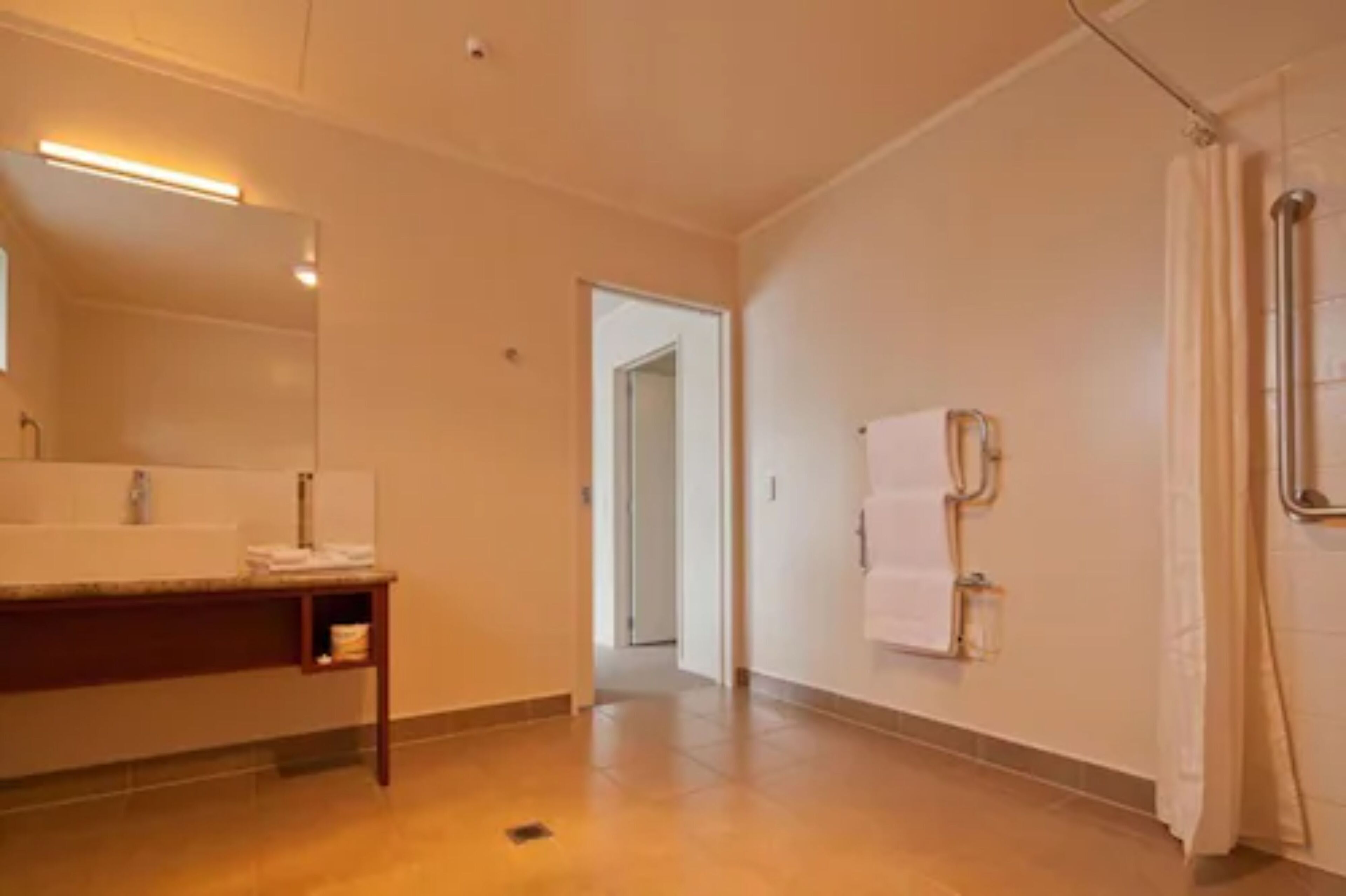 Ein modernes Badezimmer mit Waschbecken, Spiegel und Duschbereich.