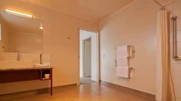 A modern bathroom with a sink, mirror, and shower area.