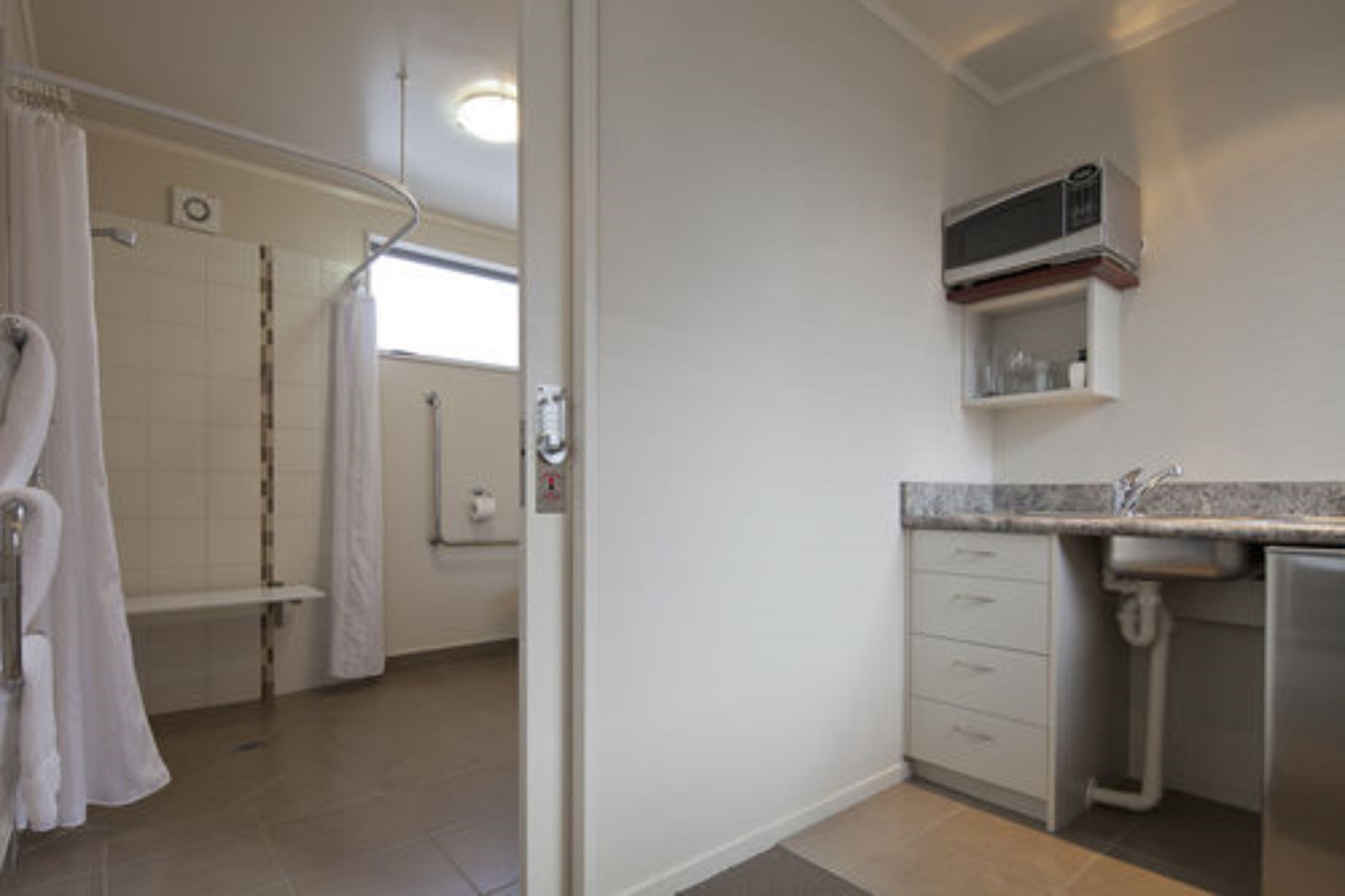 A bathroom with a shower, toilet, and sink.