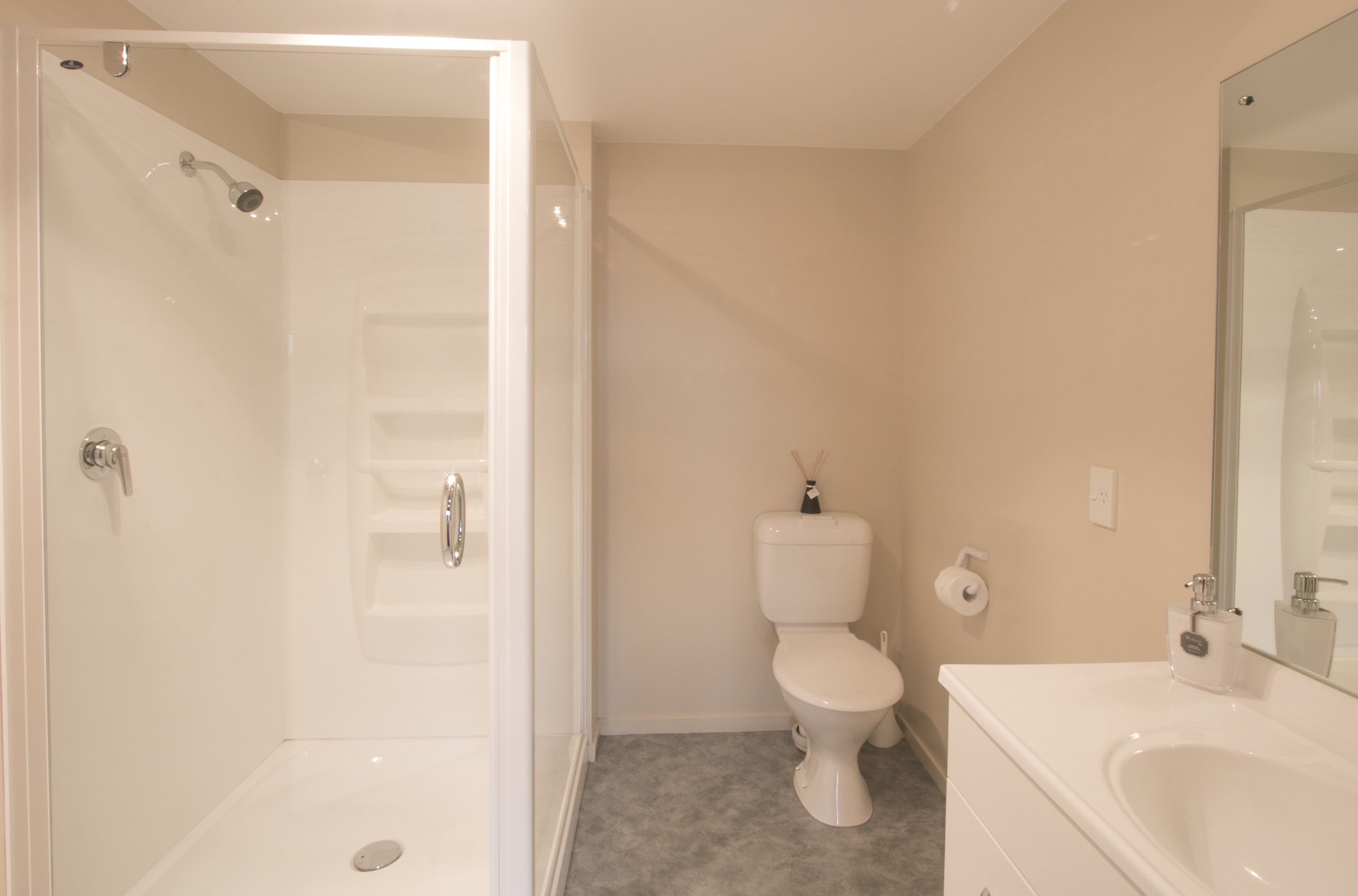 A bathroom with a shower, toilet, and sink.