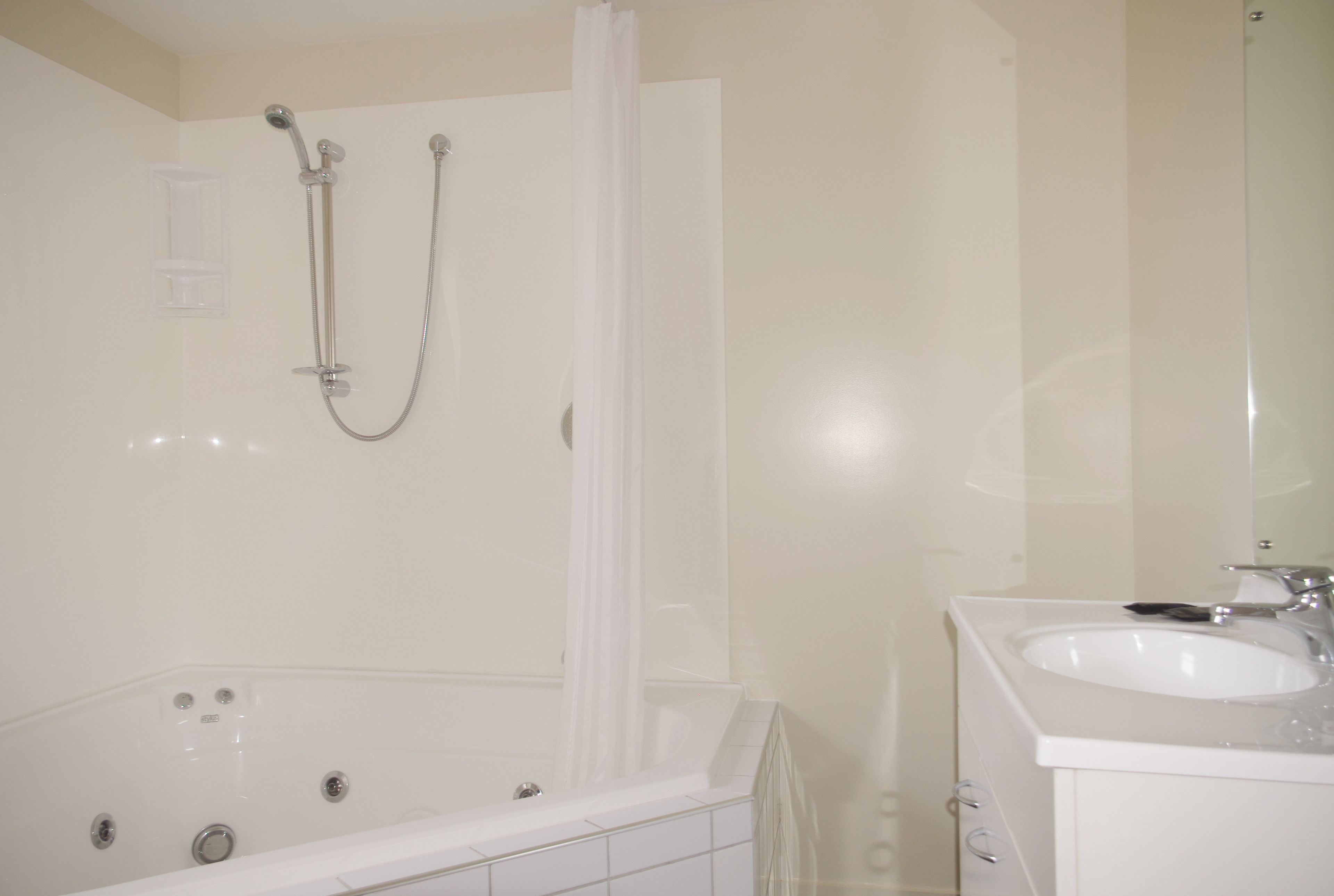 A bathroom with a bathtub, a shower, and a sink.