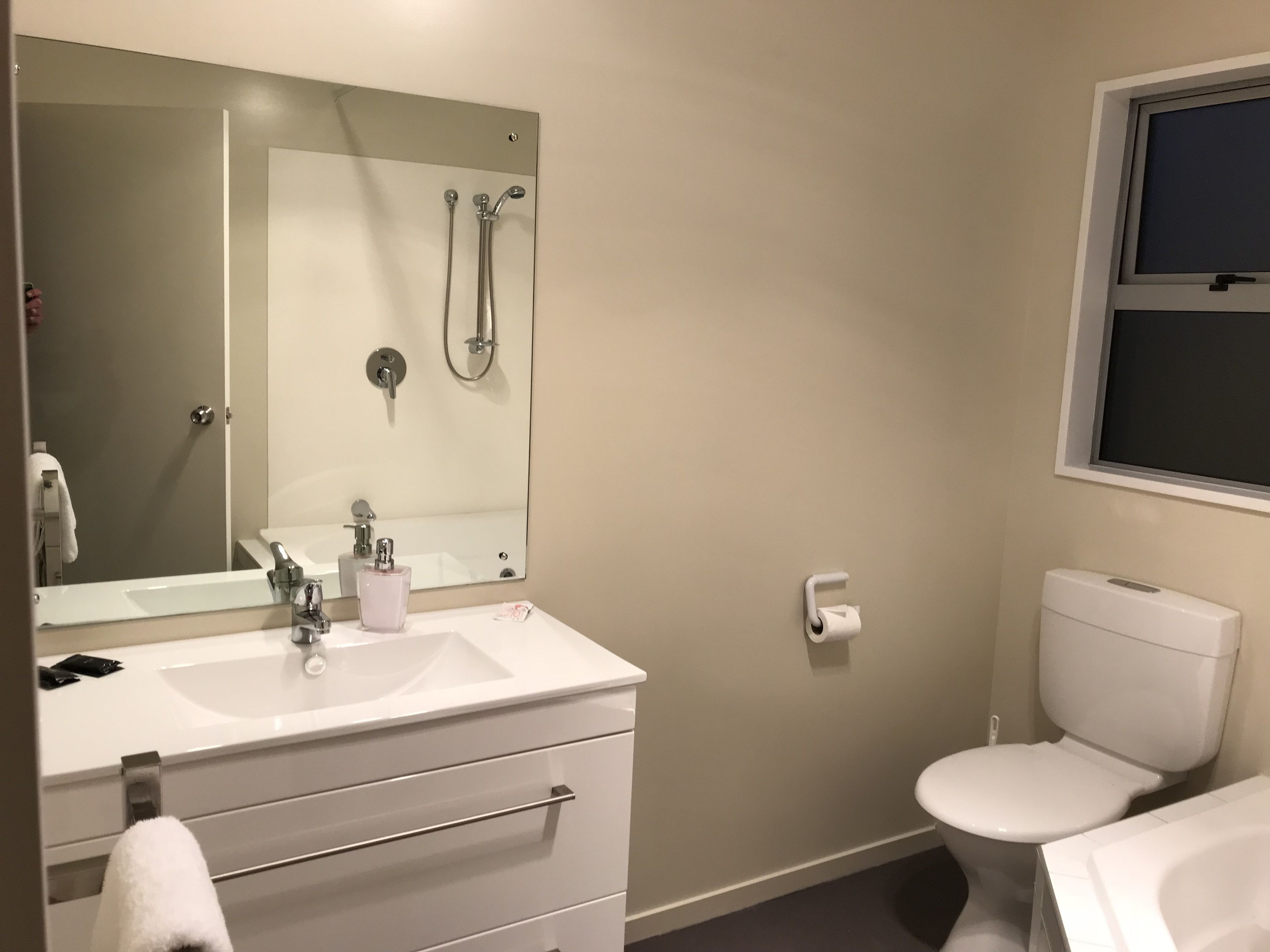 Ein Badezimmer mit Waschbecken, Spiegel und Toilette.