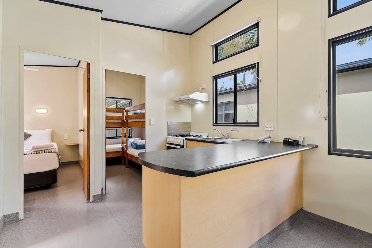 A compact kitchen with a central island, a built-in stove, and a window above the sink.