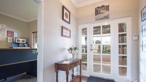 A reception area with a wooden desk, framed certificates, a vase with flowers, and a sign that says "Trust Your Journey."