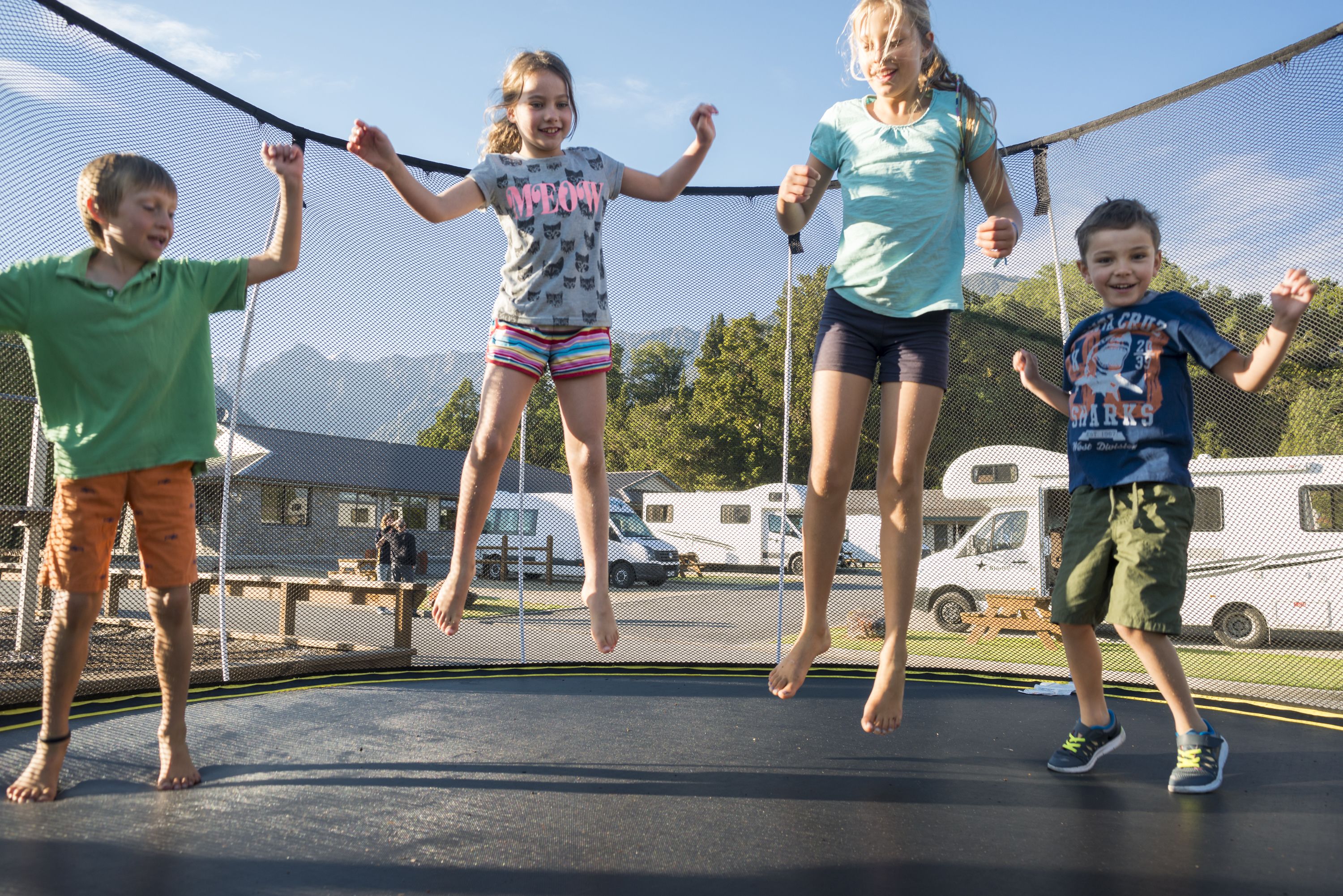 A trampoline with four children jumping.