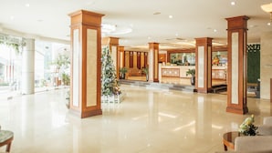 Eine geräumige Lobby mit Empfangstresen, großen Holzsäulen und einem Weihnachtsbaum.
