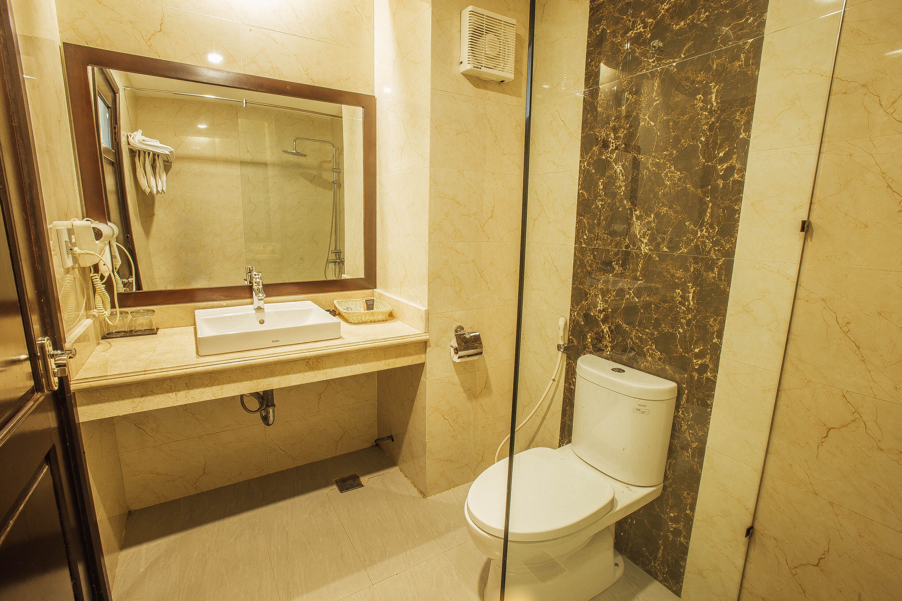 Ein Badezimmer mit Waschbecken, Spiegel und Toilette.