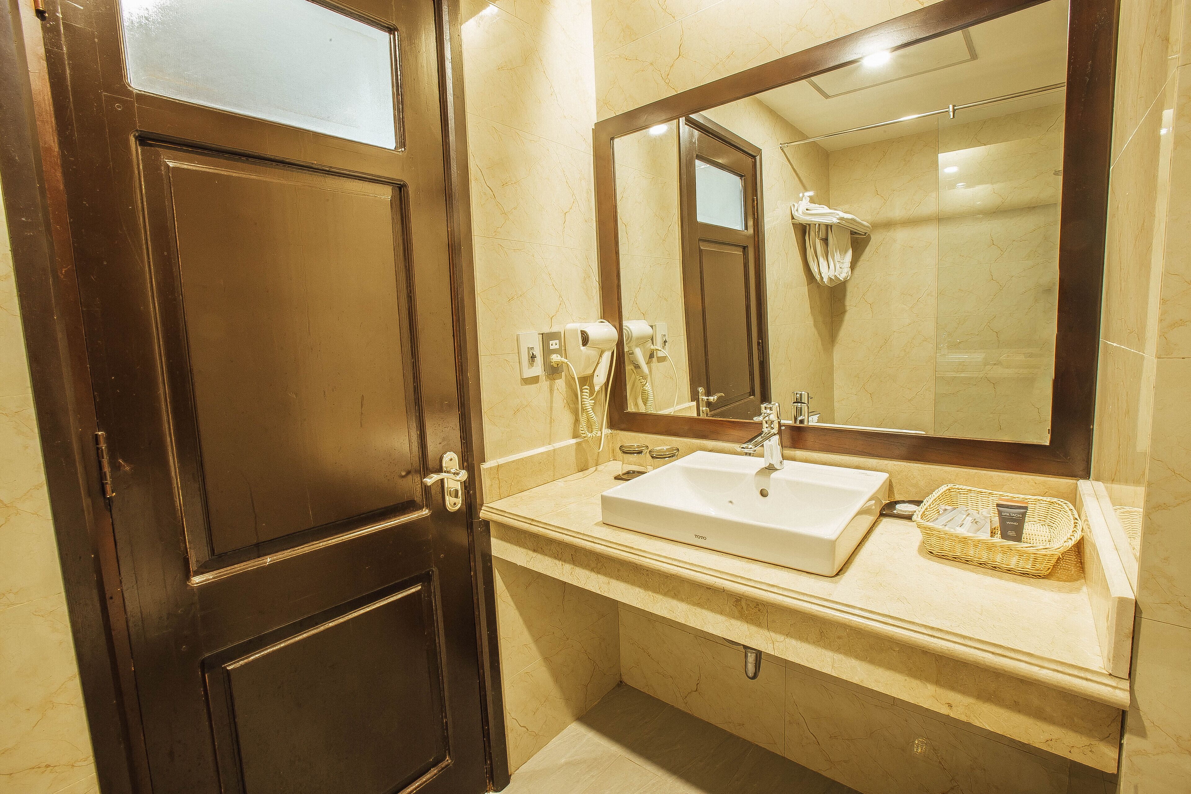 A bathroom with a white sink, a mirror, and a shower.