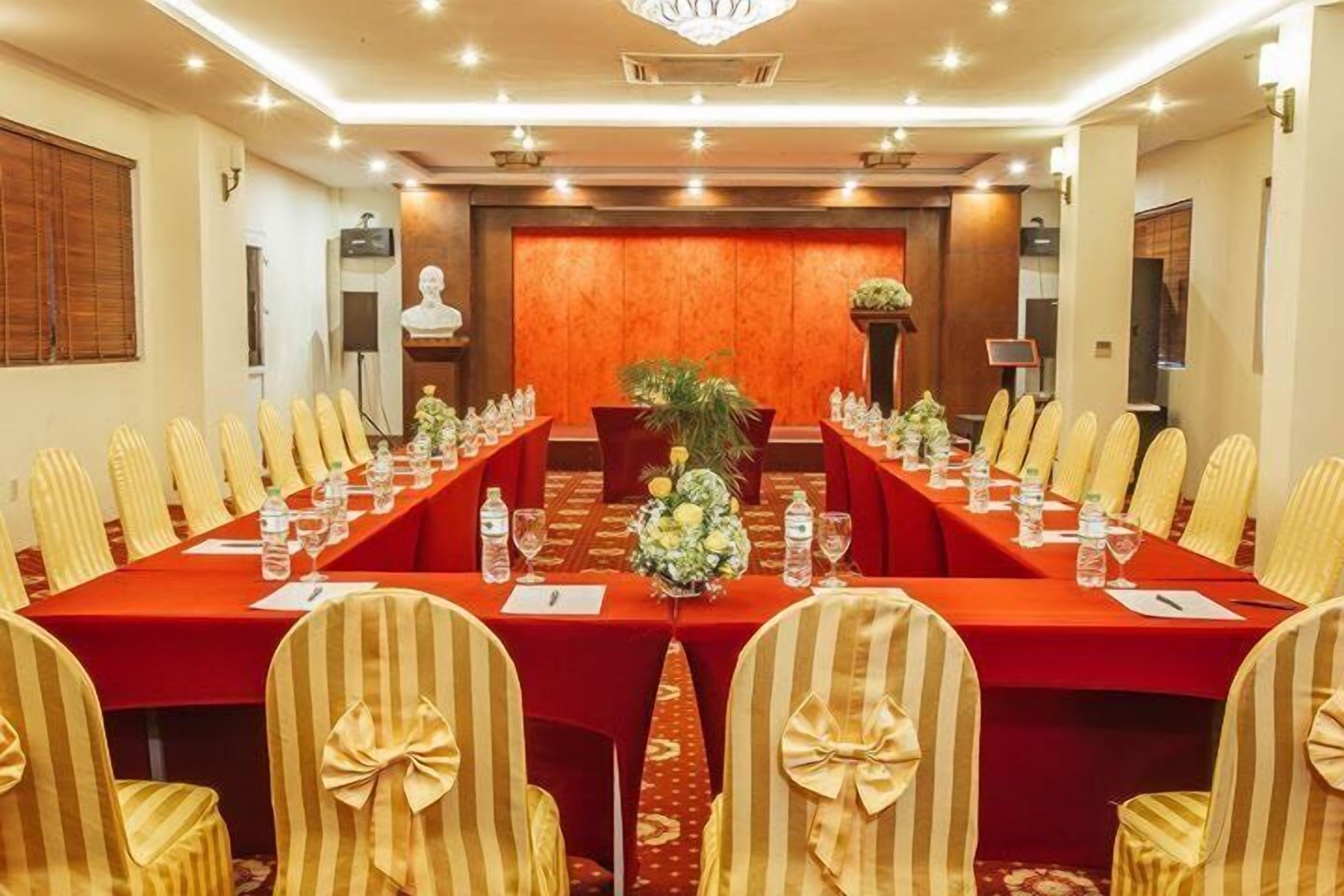 A conference room with a long table, chairs, and a podium.