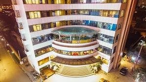 Ein mehrstöckiges Hotel mit Innenhof, Balkonen und einem Schwimmbad.