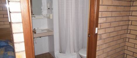 A small bathroom with a shower curtain, a toilet, and a sink.