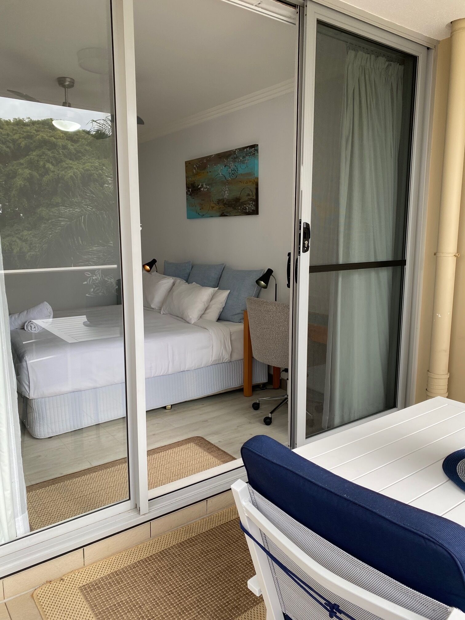 A bedroom with a bed, a desk, and a chair.