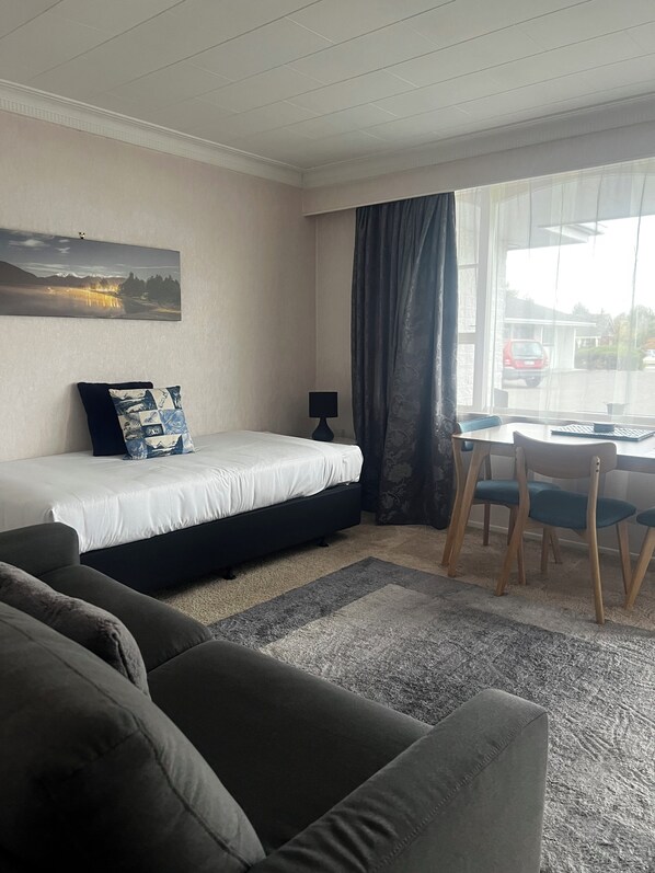 غرفة عادية - سرير ملكي | منطقة المعيشة | تلفزيون بحجم 49-بوصة يعرض قنوات تلفزيونية رقمية