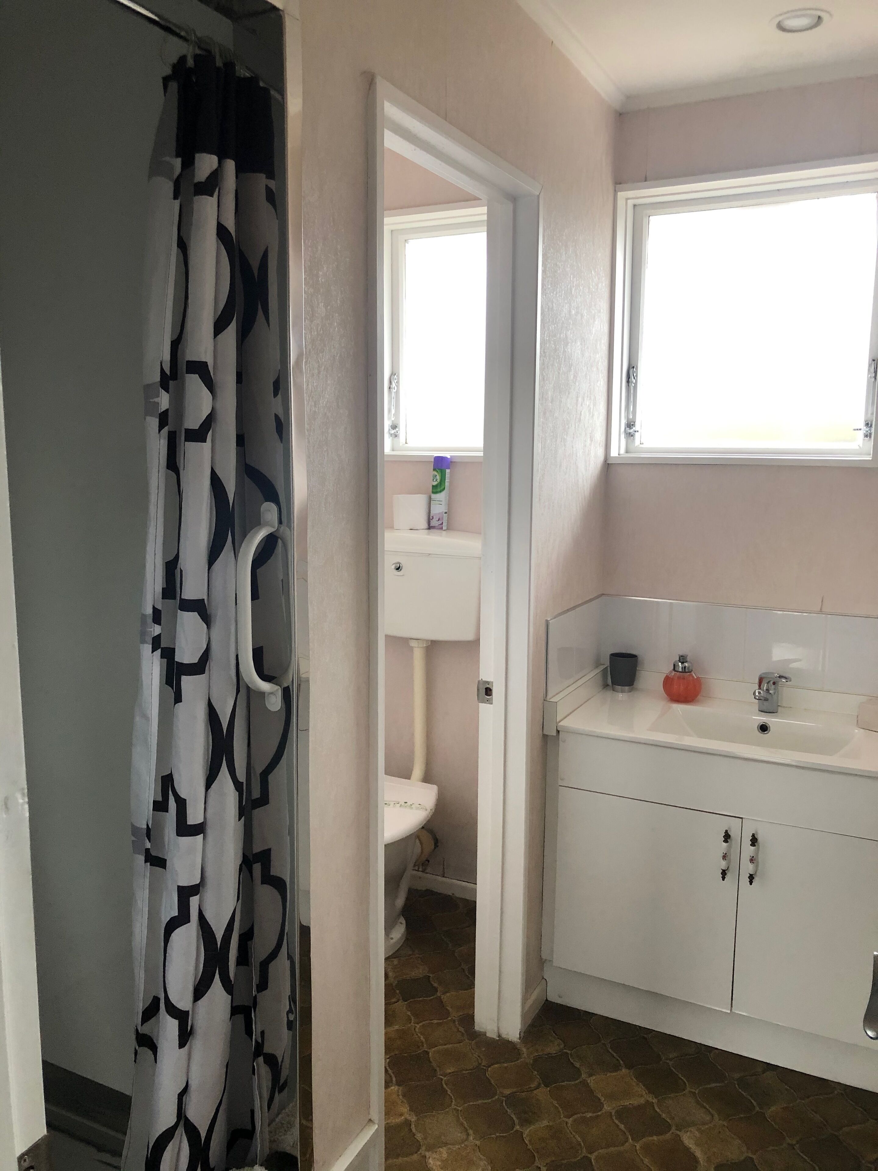 Un bagno con servizi igienici, lavandino e finestra.