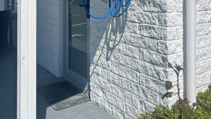 Una estación de carga para vehículos eléctricos fijada a la pared, con un cable azul.