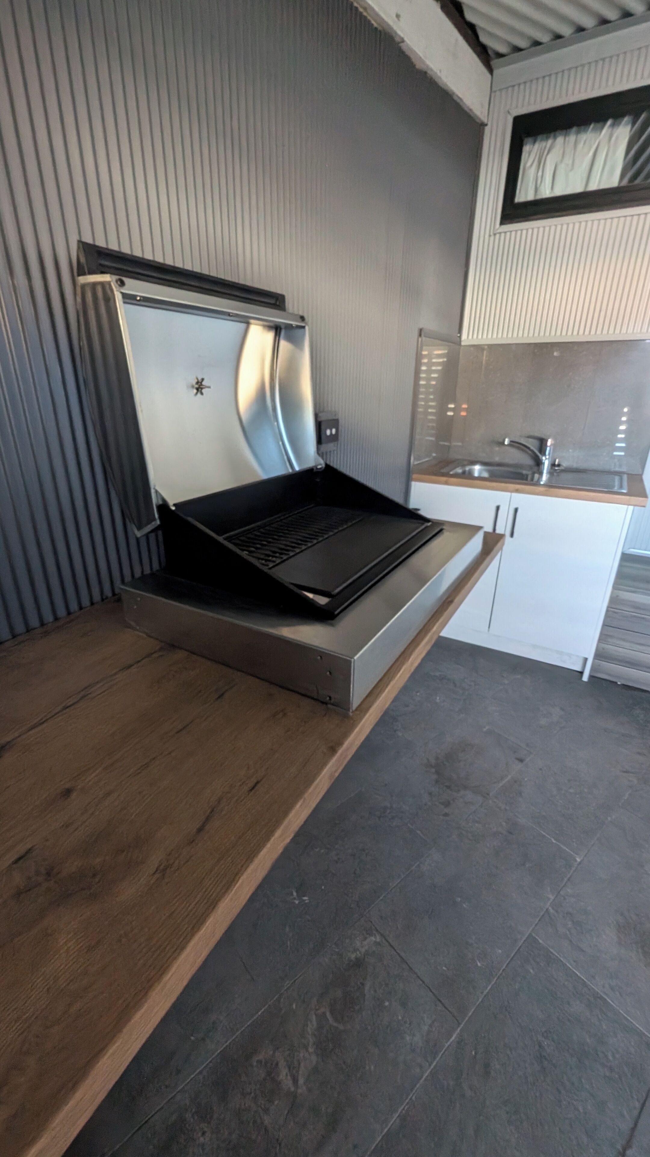 A kitchen with a built-in stove, a sink, and a wooden countertop.