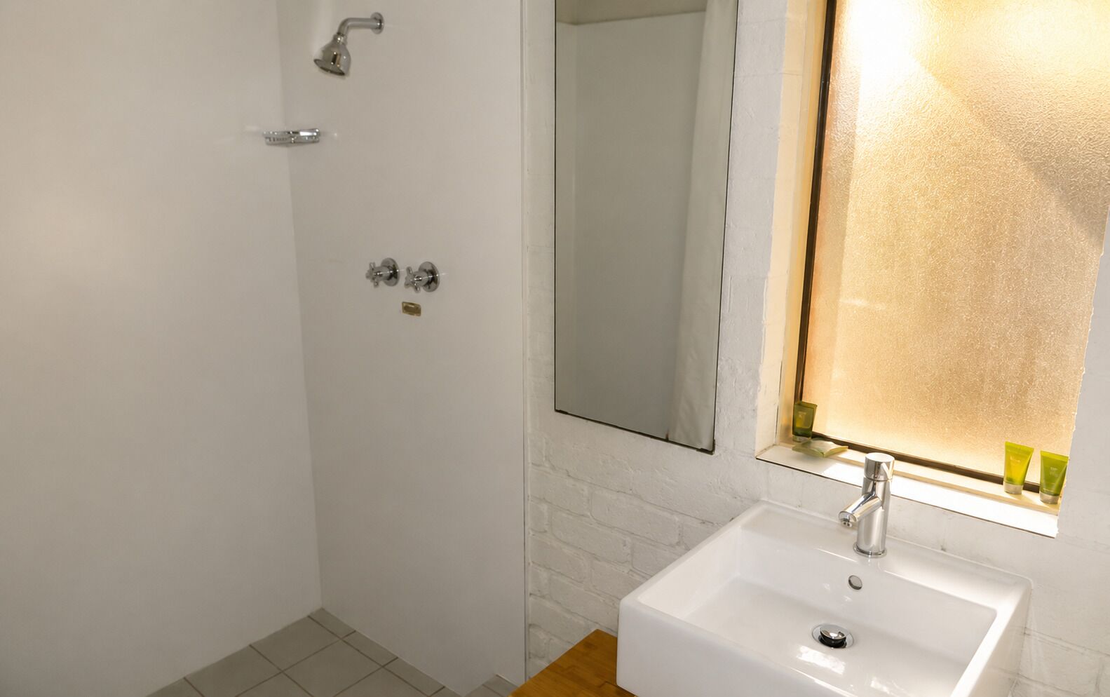 A bathroom with a shower, a sink, and a mirror.