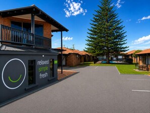 A building with a sign reading 'relaxed simple fresh' and a large tree in front. - Geraldton's Ocean West (Mahomets Flats)