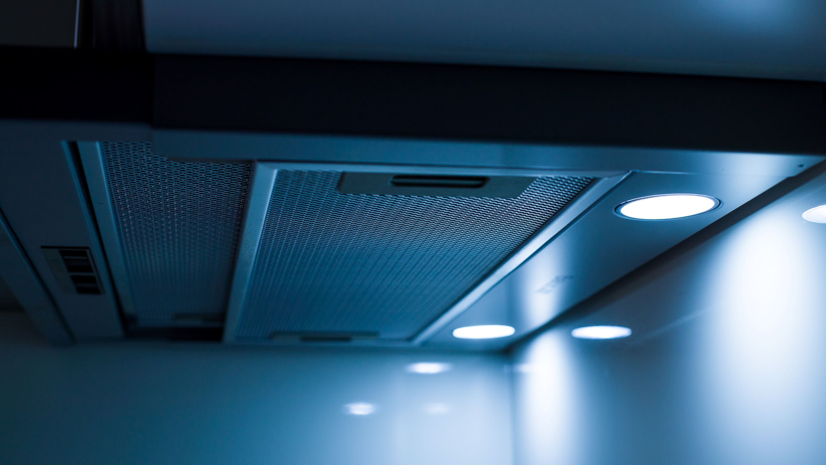 Een detailopname van een ventilatierooster met een gaasroede en bedieningspaneel.