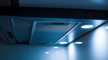 Een detailopname van een ventilatierooster met een gaasroede en bedieningspaneel.