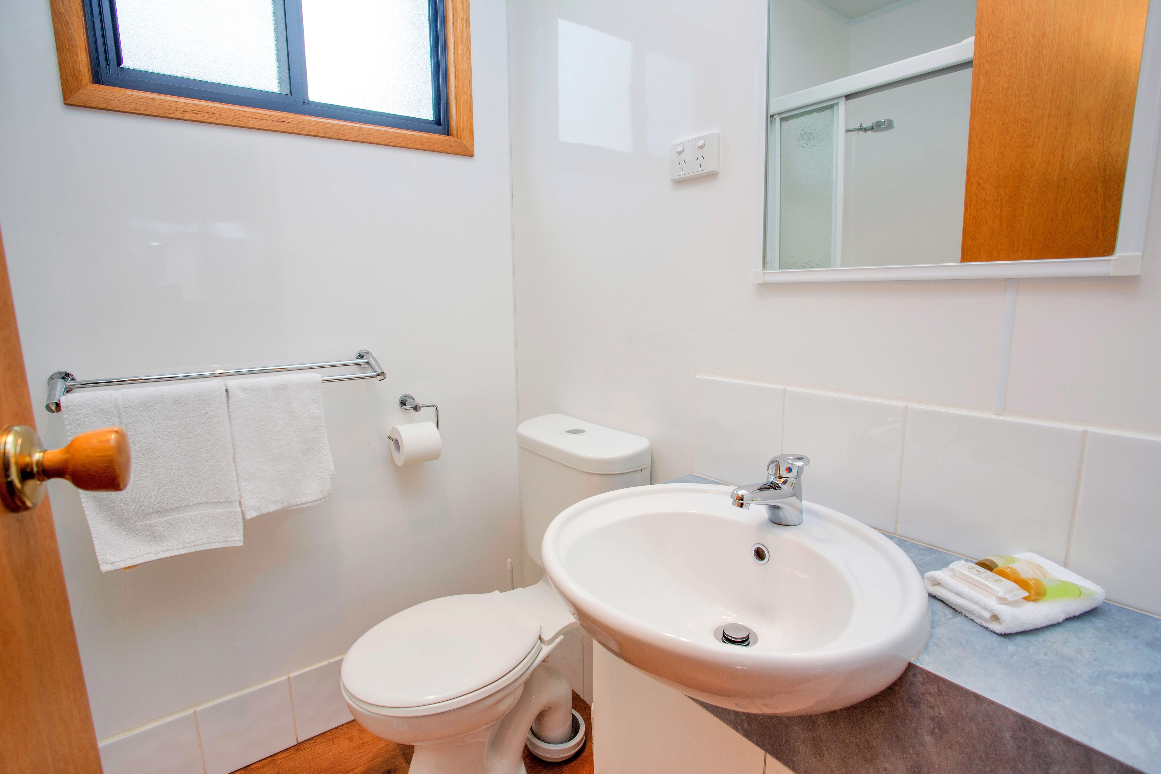 Ein Badezimmer mit Toilette, Waschbecken und Handtuchhalter.