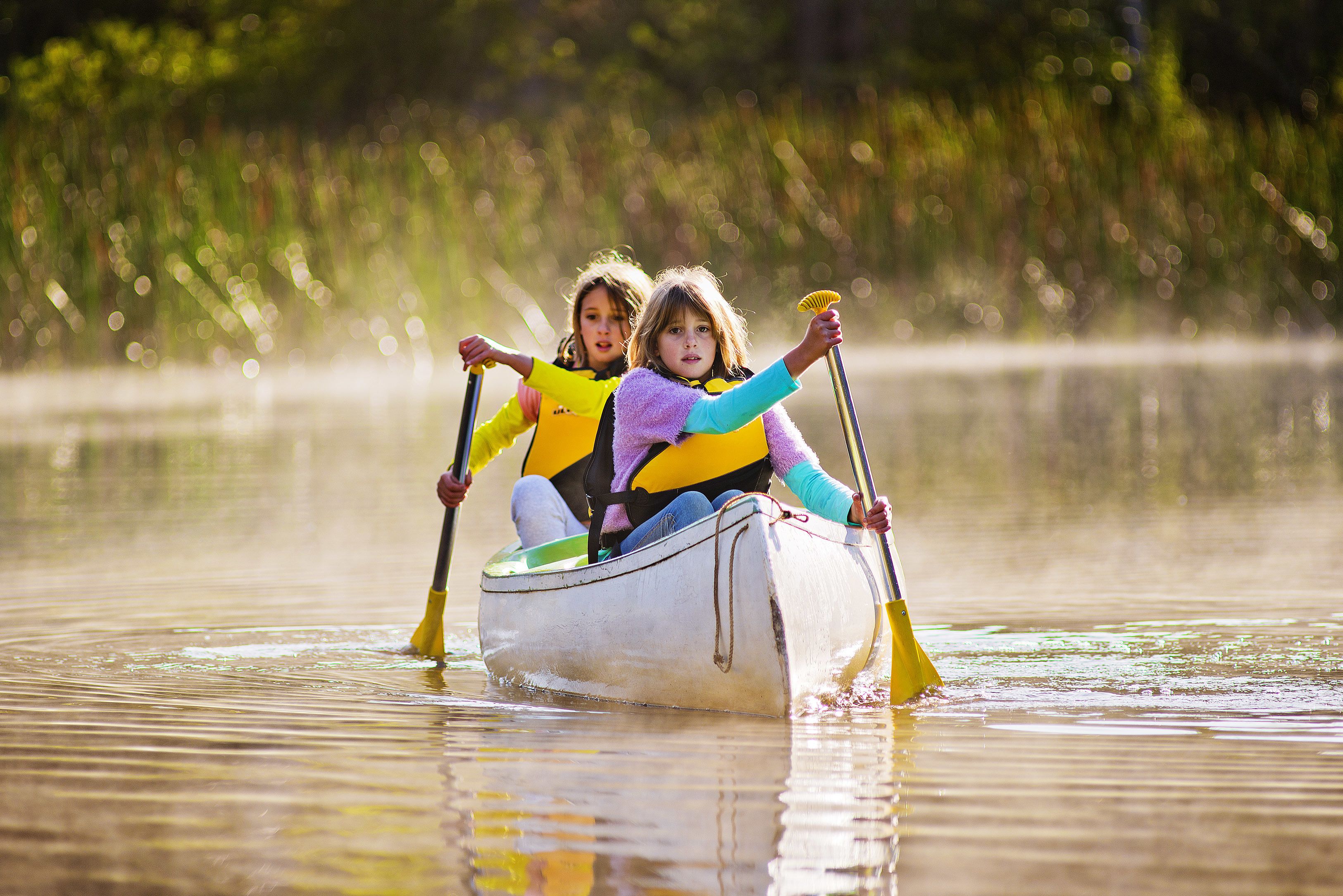 Dos personas en una canoa sobre aguas tranquilas.