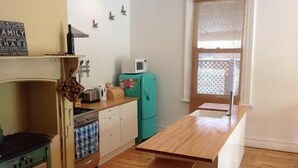 A compact kitchen with a wooden countertop, a teal refrigerator, a microwave, and a sink. - Tin House at Tanunda (Tanunda)