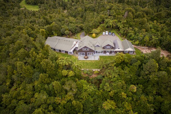A large, multi-story house surrounded by dense forest. - Patuha Rainforest Retreat (Pitone)