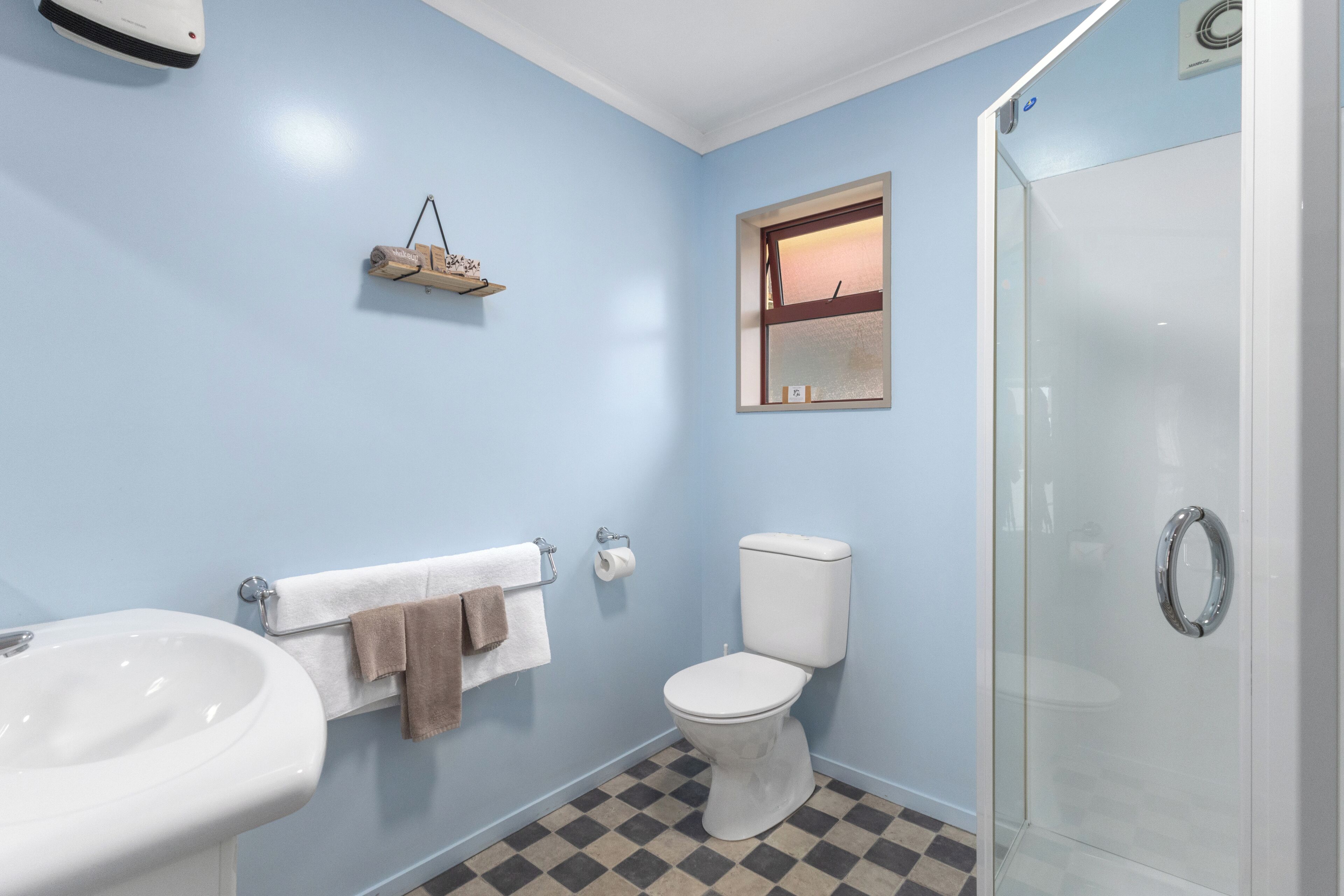 A bathroom with a sink, toilet, and glass shower enclosure.