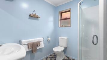 A bathroom with a sink, toilet, and glass shower enclosure.