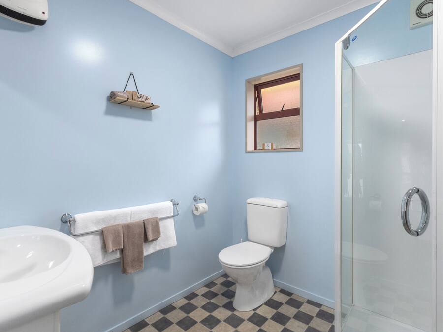 A bathroom with a sink, toilet, and glass shower enclosure.