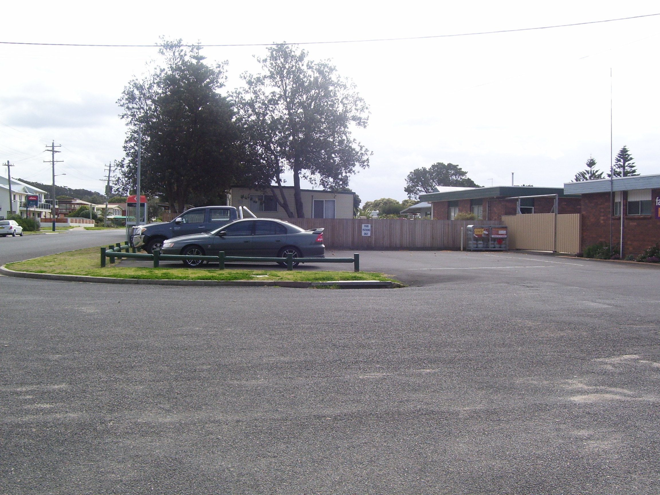 A parking area with a car and a building in the background.
