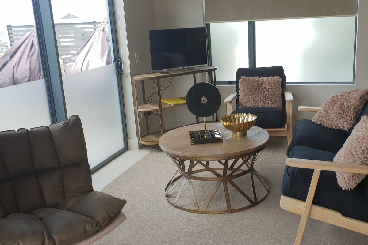 Un salon moderne avec un canapé, un fauteuil et une table basse.