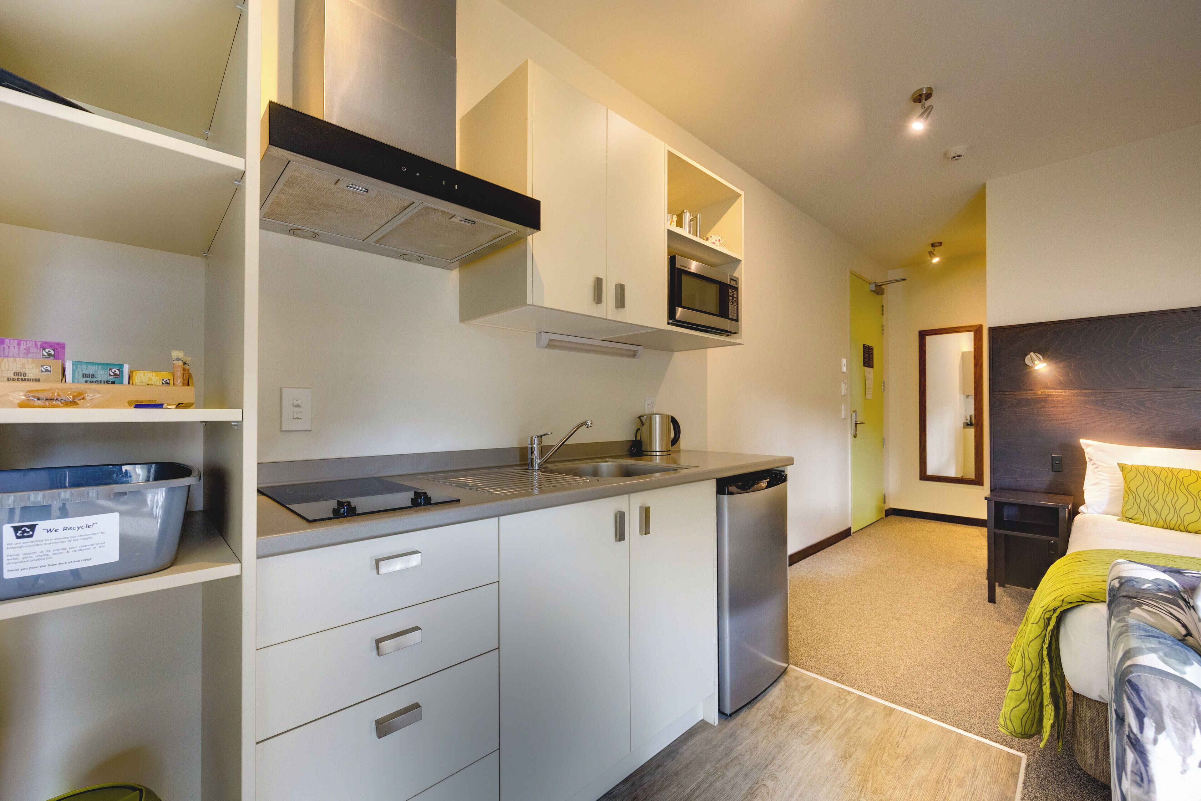 A modern kitchen with white cabinets, a stainless steel dishwasher, and a microwave.