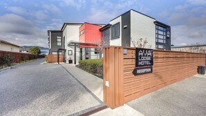 A modern building with a reception area, a red section, and a sign indicating it's a lodge motel. - Ava Lodge (Lower Hutt)