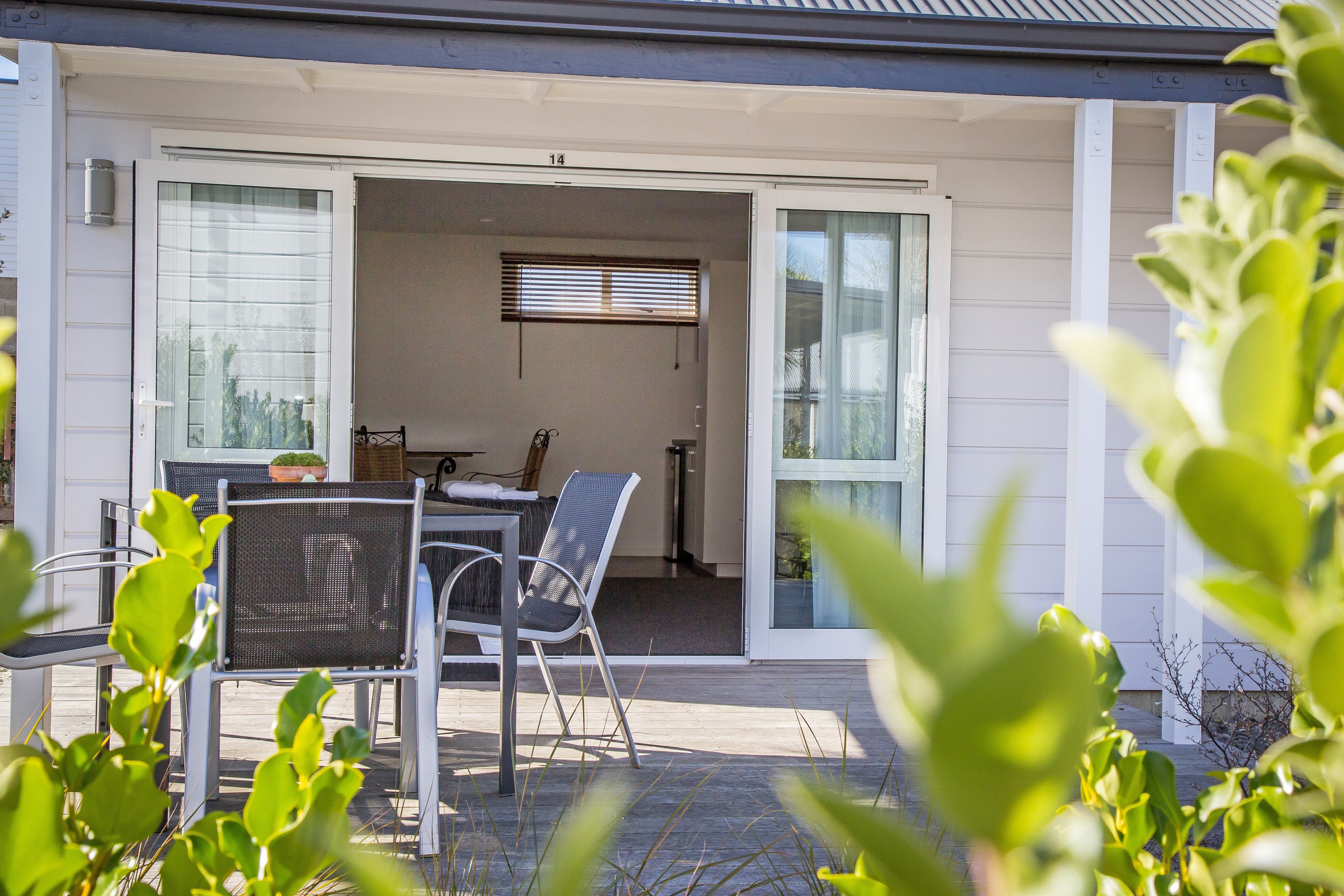 A patio with a table and chairs, a sliding glass door, and a view of the interior.