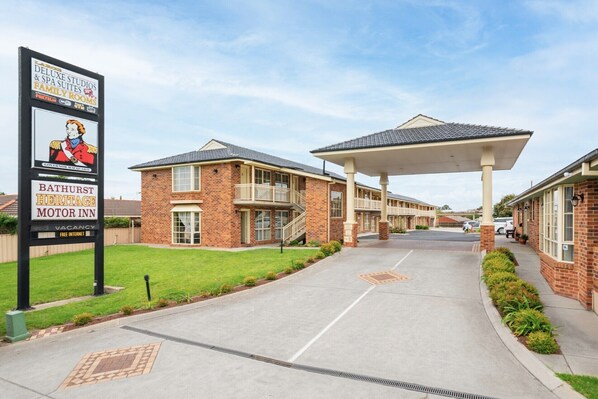 A two-story brick building with a covered walkway and a sign advertising a motor inn. - Heritage Inn Bathurst (Bathurst)
