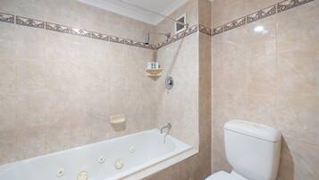 Un baño con bañera, inodoro y ducha.