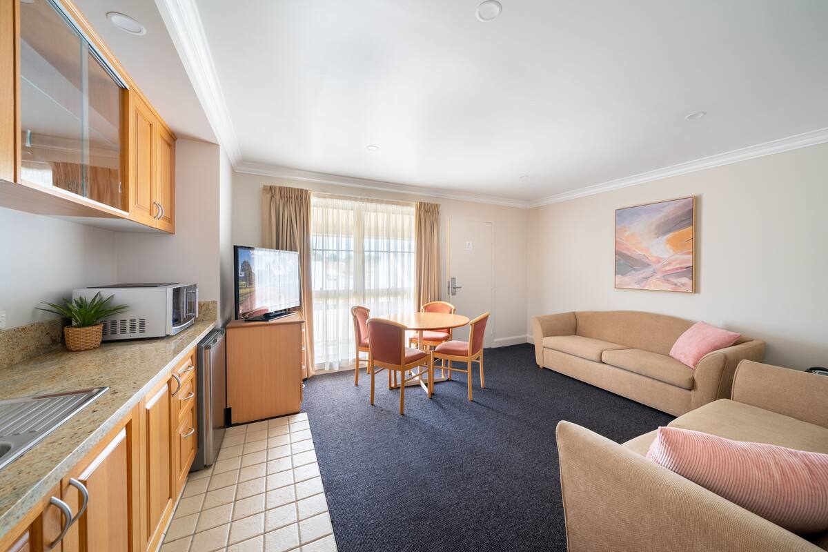 A compact living space with a kitchenette, dining area, and seating area.