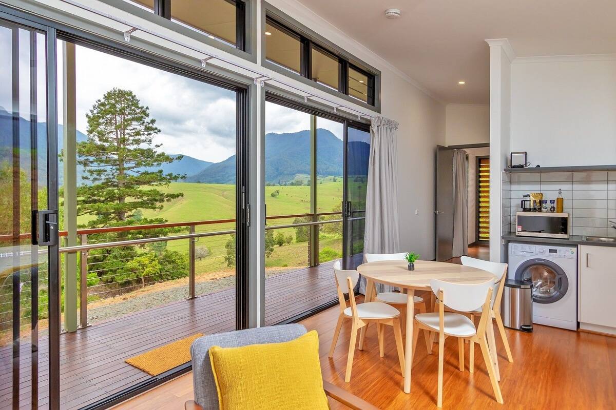 A modern kitchen with a washing machine and a dining area with a table and chairs.