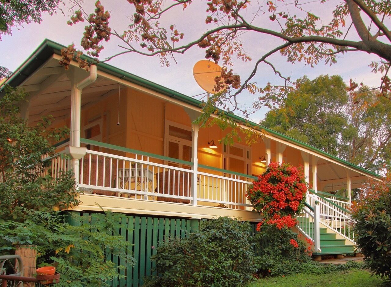 A two-story house with a balcony, a satellite dish, and a staircase leading to the upper level.