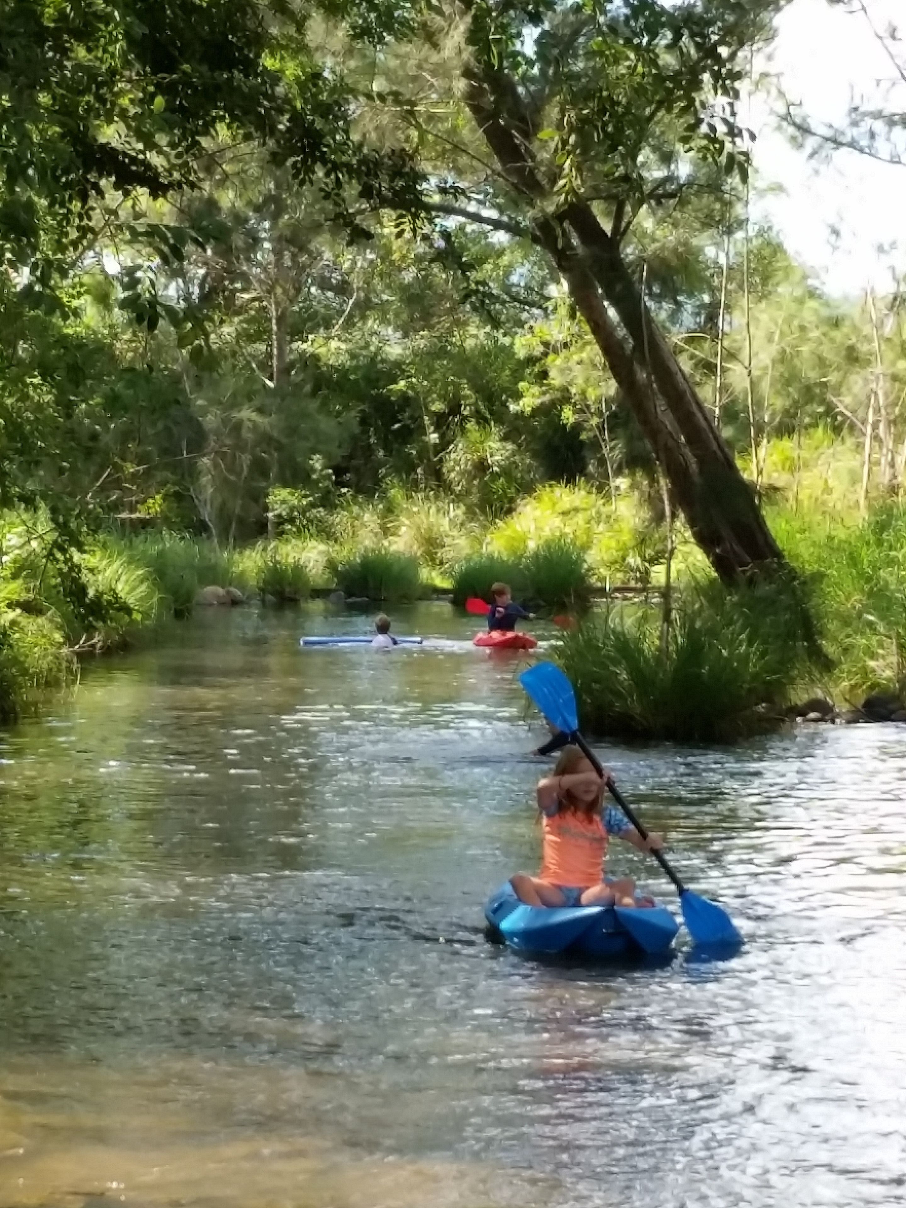 Un río con kayaks y una persona remando.