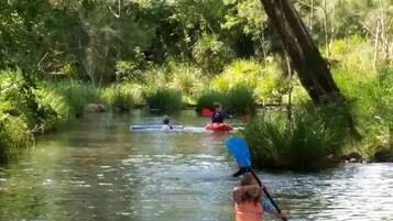 Un río con kayaks y una persona remando.