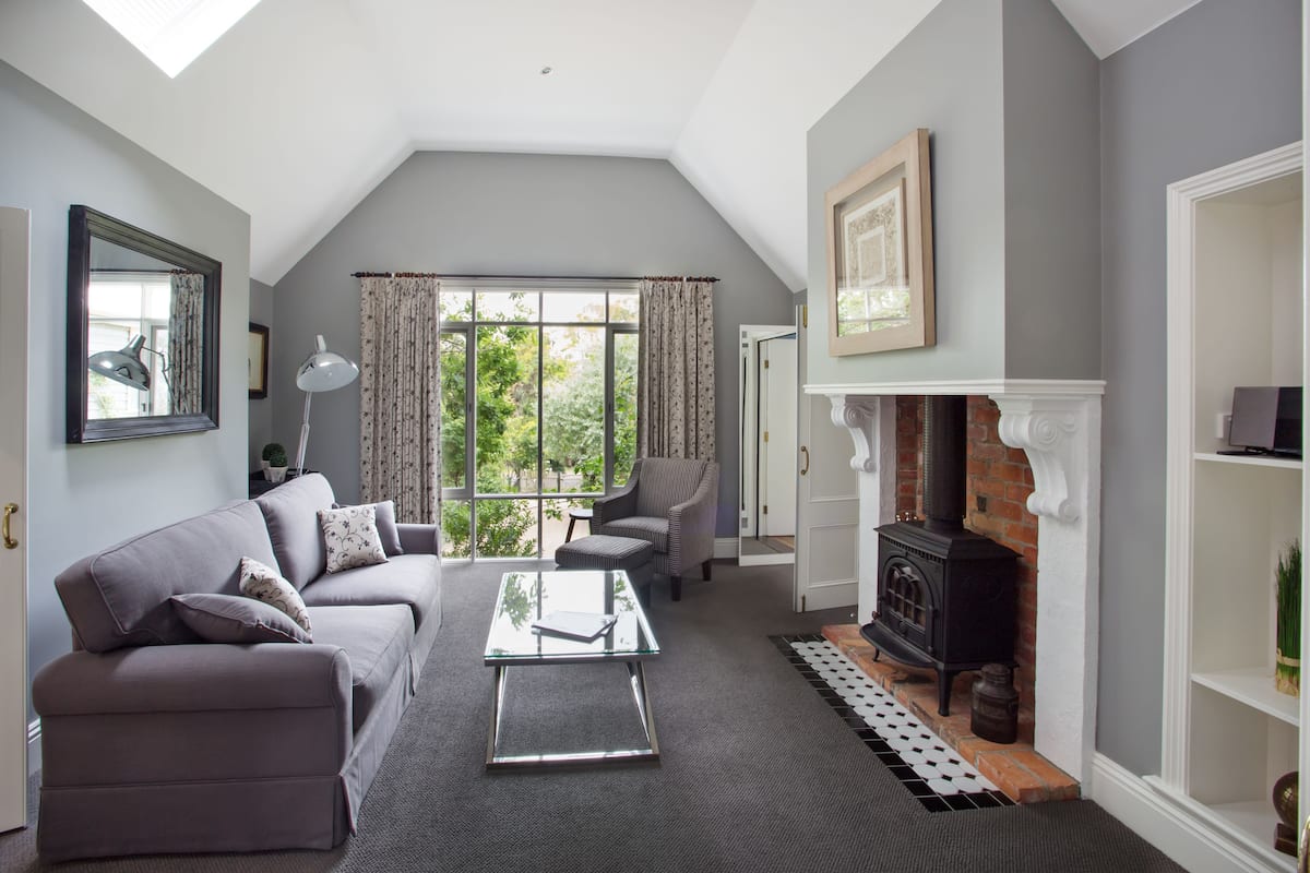A living room with a sofa, armchair, and a fireplace.