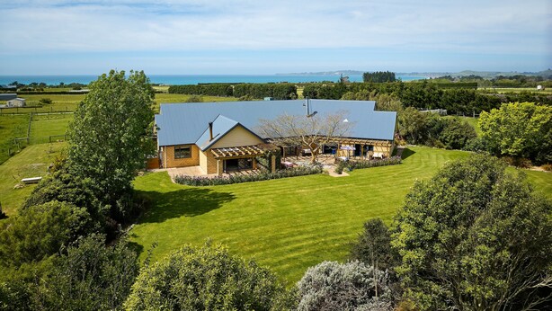 A house with a sloped roof, surrounded by a well-maintained lawn and trees. - Awatea Country B&B (Hapuku)