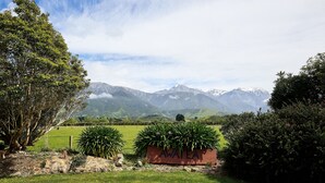 A grassy field with a sign reading "AWATEA" and mountains in the background. - Awatea Country B&B (Hapuku)