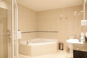 Un baño moderno con una bañera independiente, cabina de ducha de cristal y un lavabo con encimera de mármol.