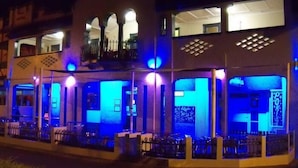 A two-story building with a balcony on the upper floor, featuring a seating area with tables and chairs. - McGuire's CBD Hotel (Mackay)